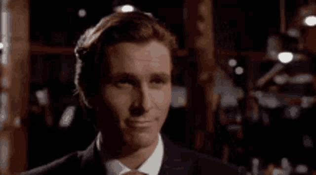 a man in a suit and tie is smiling in a room .