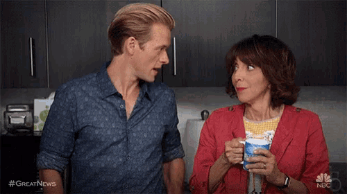 a man and a woman are looking at each other while eating food .
