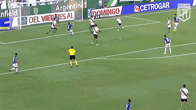 a group of soccer players are playing on a field with an advertisement for banfield behind them