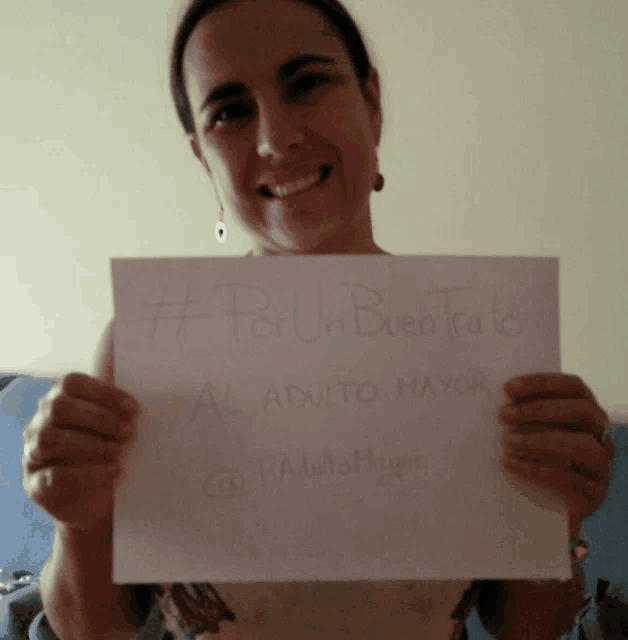 a woman holds up a sign that says " por un buen trao "