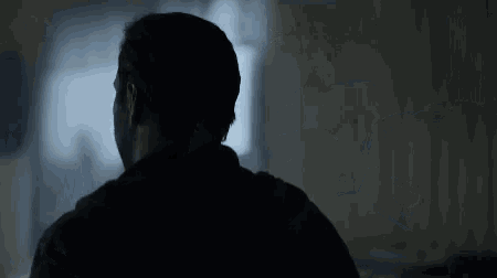the back of a man 's head is shown in the dark