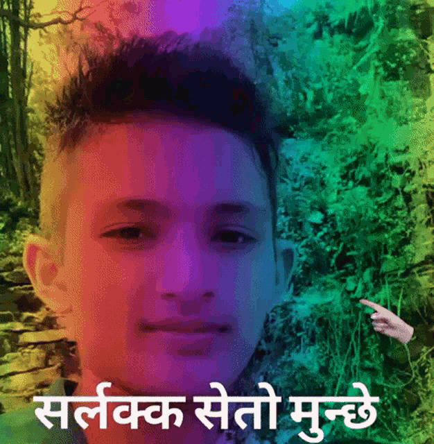 a boy with a rainbow haircut is standing in front of a rainbow background with a hand pointing at him