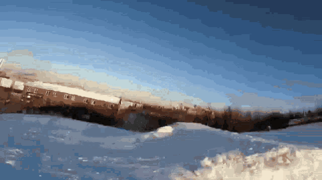 a blurry picture of a snowy landscape with a blue sky in the background