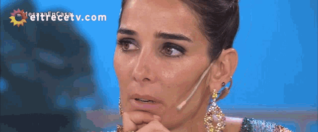 a close up of a woman 's face with the website eltrecetv.com in the corner
