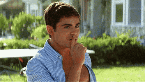 a man in a striped shirt is covering his mouth with his hand