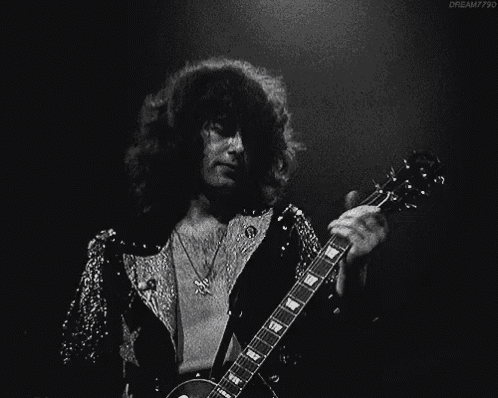 a black and white photo of a man playing a guitar with dream7790 in the lower right corner