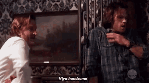 two men are standing next to each other in a room and one of them is saying hi ya handsome .