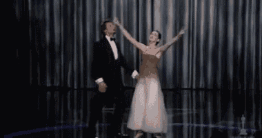 a man and a woman are dancing on a stage .