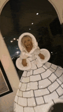 a woman is wearing a white igloo costume .
