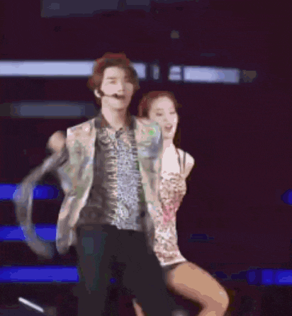 a man and a woman are dancing on a stage in front of a microphone .