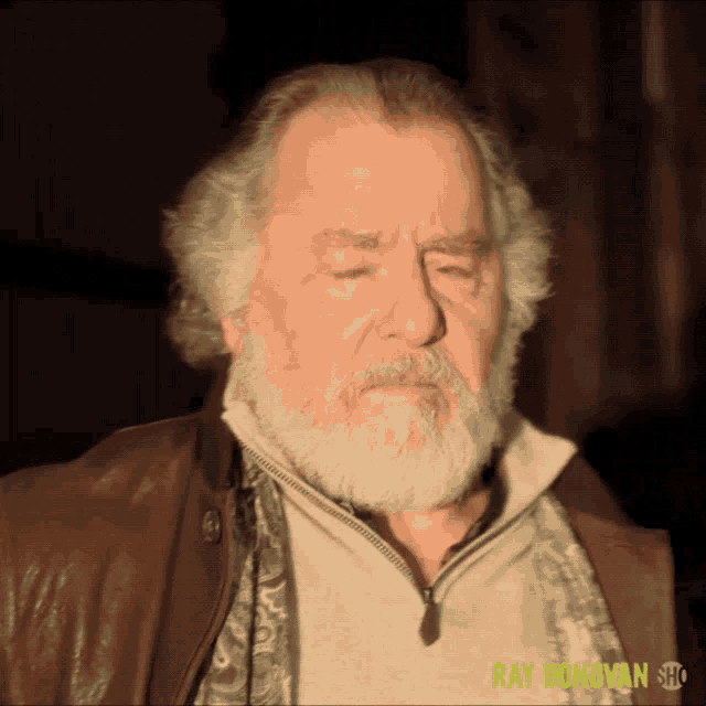 a man with a beard is wearing a brown jacket and a scarf