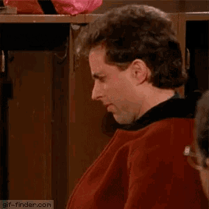 a man in a red jacket is smiling in front of a locker