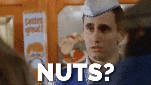 a man in a blue apron is asking for nuts