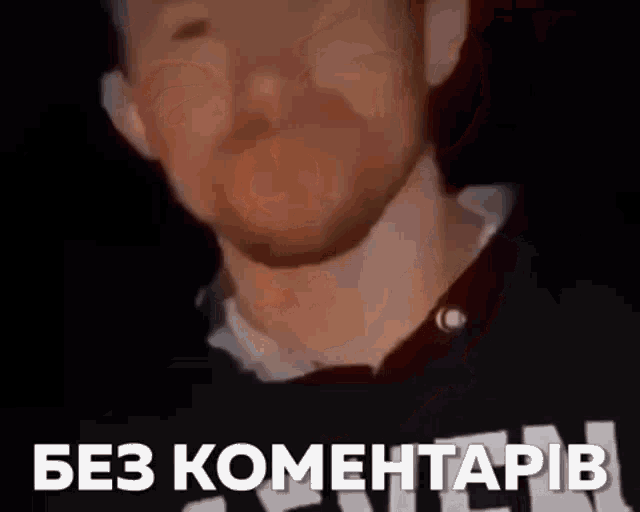 a man with a beard is wearing a black shirt with the words " без коментарів " on it