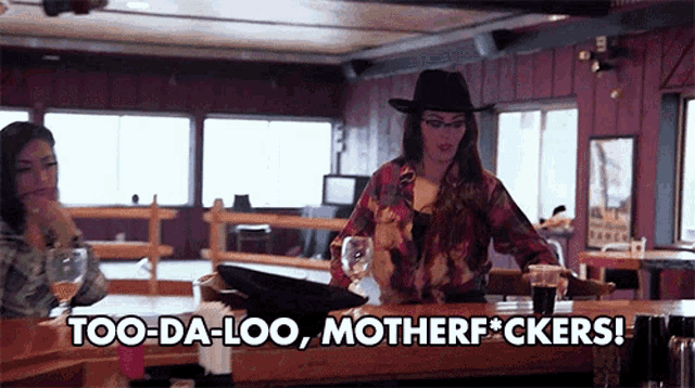 a woman sitting at a bar with the words too-da-loo motherfuckers