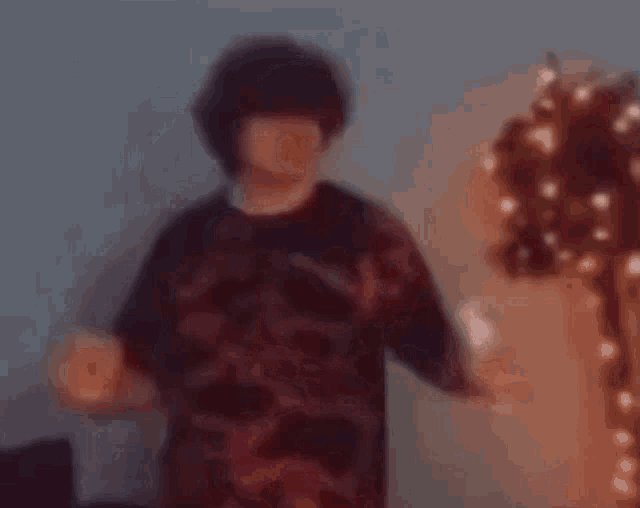 a blurry picture of a person holding a wii controller in a room .