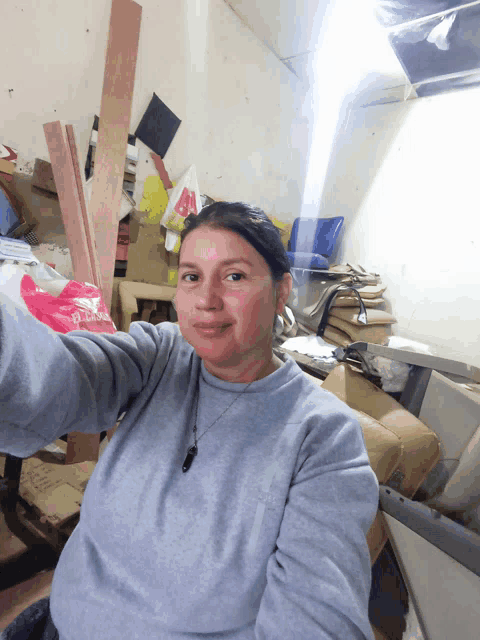 a woman taking a selfie in a messy room with a bag that says ' abercrombie & fitch ' on it