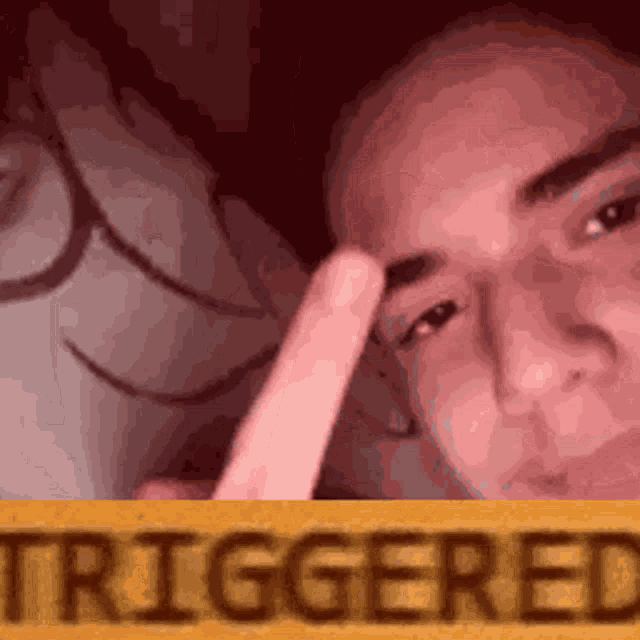 a close up of a person 's face with a sign that says triggered in the background .