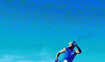 a man in a blue shirt is jumping in the air