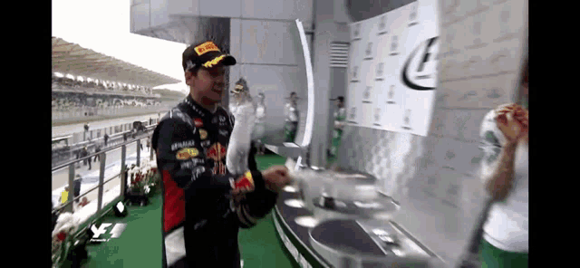 a man in a red bull shirt is holding a trophy .