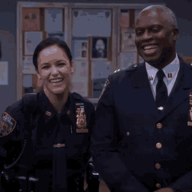 a man and a woman are posing for a picture and the woman has a patch on her uniform that says nypd on it