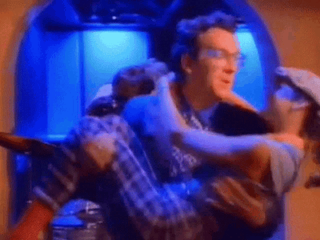 a man is carrying a woman in his arms in an elevator in a room .