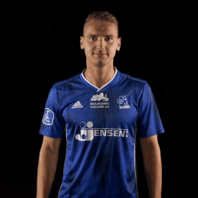 a man wearing a blue adidas shirt points up