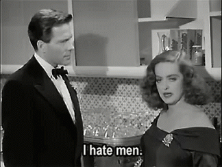 a man in a tuxedo stands next to a woman in a black dress and says i hate men