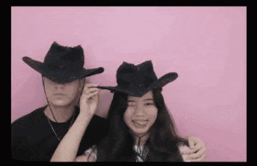 a man and a woman are wearing cowboy hats on a pink background