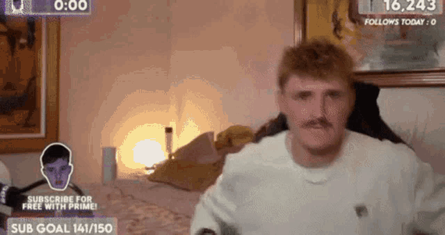 a man with a mustache is sitting on a bed in a bedroom .
