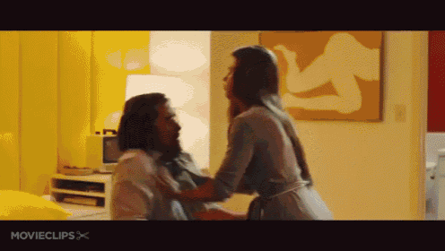 a man and a woman are kissing in a room with movieclips written on the bottom of the screen .