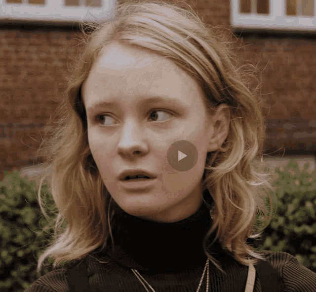 a close up of a woman with a play button on her face