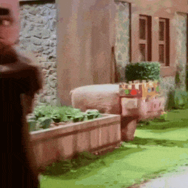 a pig with a castle on its head is in a garden