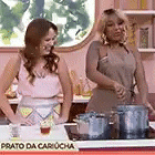 two women are standing next to each other in a kitchen with pots on the stove .