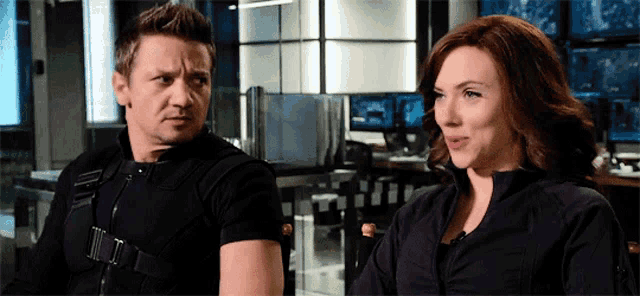 a man and a woman sitting next to each other in a room