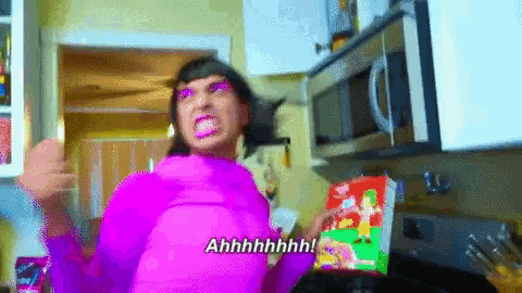 a woman in a purple shirt is holding a box of cereal and says ahhhh