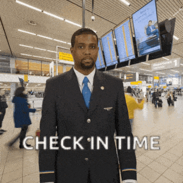 a man in a suit and tie stands in an airport with the words check in time above him