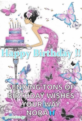 a woman in a pink dress blowing out candles on a birthday cake .