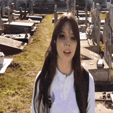 a girl stands in a cemetery with a backpack on