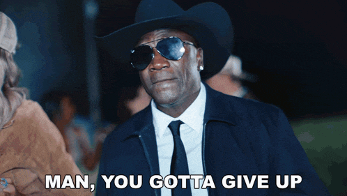 a man in a suit and cowboy hat says man you gotta give up