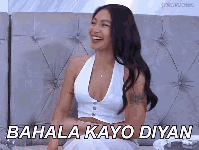 a woman in a white top is sitting on a couch with the words bahala kayo diyan above her
