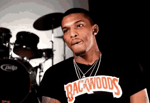 a man is wearing a black shirt with the word backwoods on it .