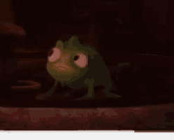 a green frog with big eyes is sitting on the ground in the dark