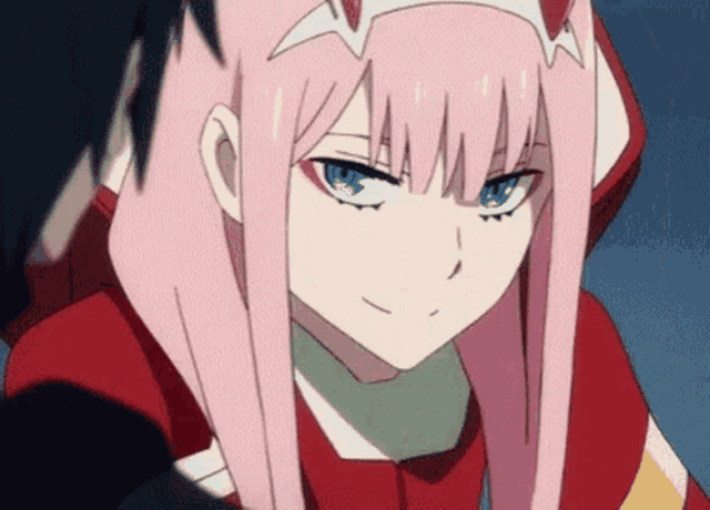 a girl with pink hair and blue eyes is smiling .