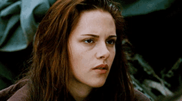 a close up of a woman 's face with long red hair