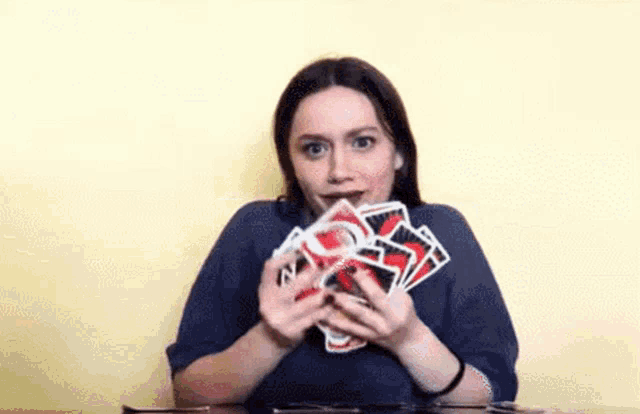 a woman is holding a bunch of cards in her hands .