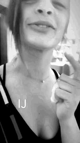 a black and white photo of a woman giving a thumbs up sign
