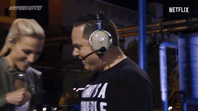 a man wearing a shirt that says that 's a double fist bumps with a woman