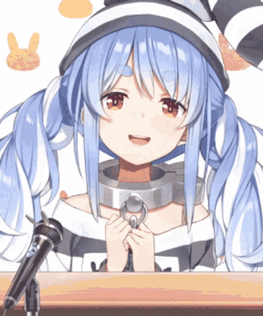 a girl with blue hair is sitting in front of a microphone and smiling