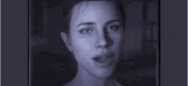 a close up of a woman 's face in a black and white photo with a purple background .